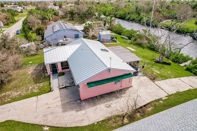 an aerial view of a house with a yard and lake view