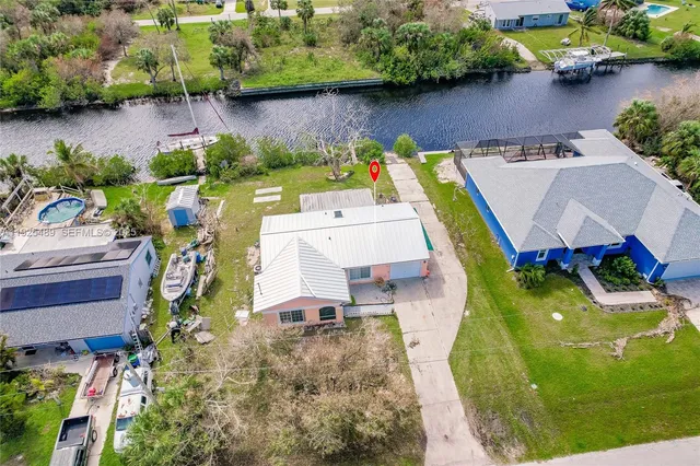 an aerial view of a house with a swimming pool and outdoor seating