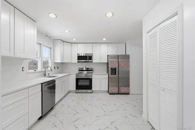 a kitchen with stainless steel appliances granite countertop a refrigerator and a sink