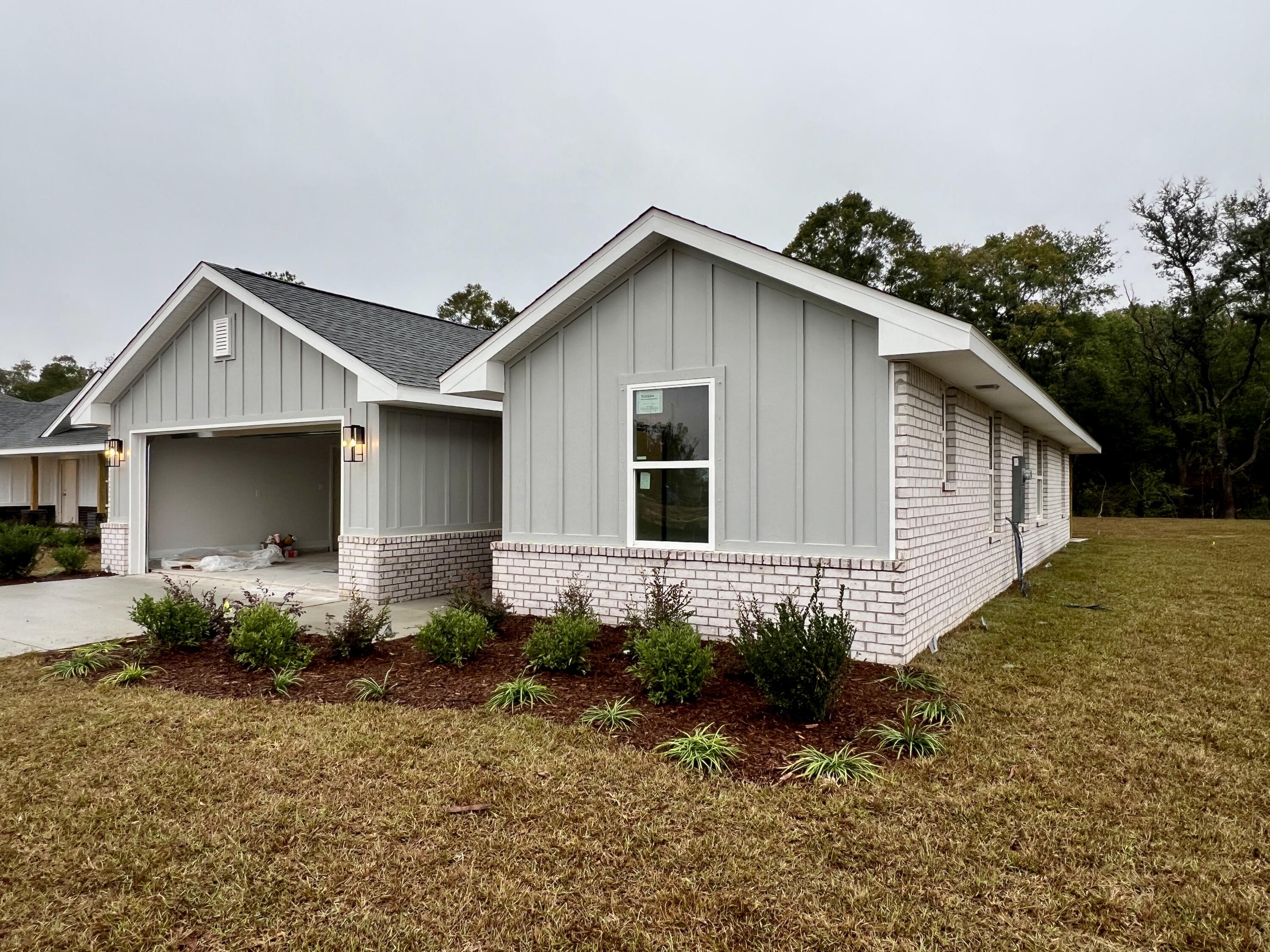 5333 Hidden Pines Circle Milton, FL 32583 - Photo 2 of 2 a front view of a house with garden
