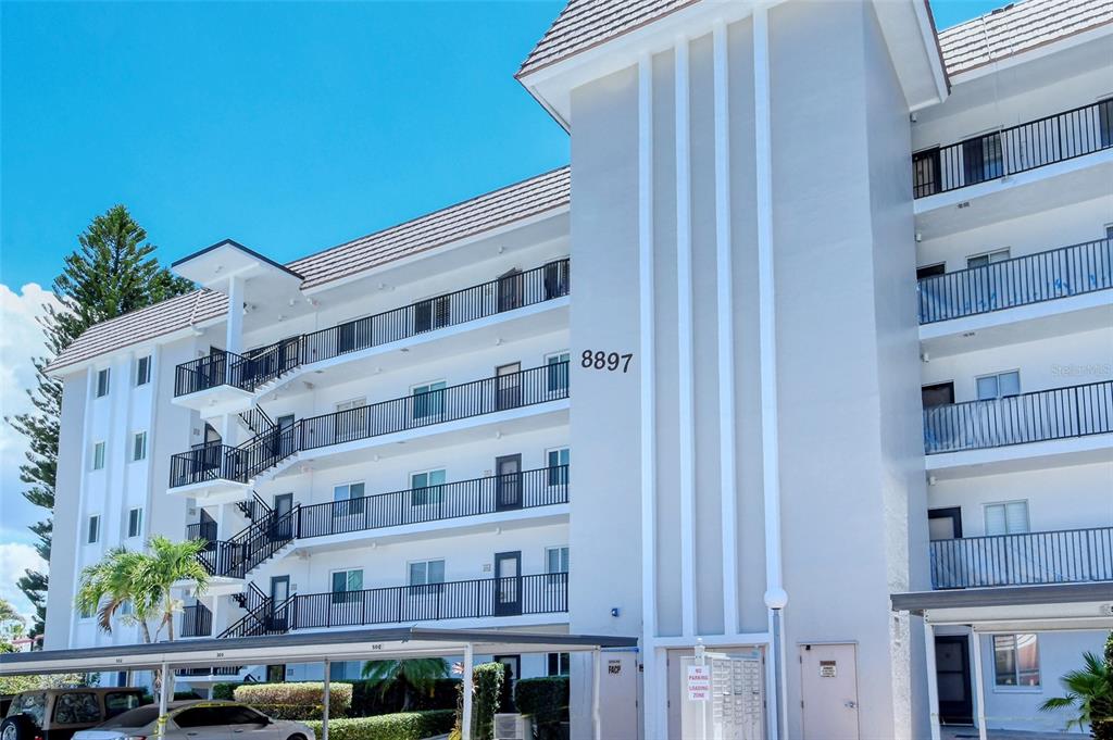 a front view of a building with balcony and staircase