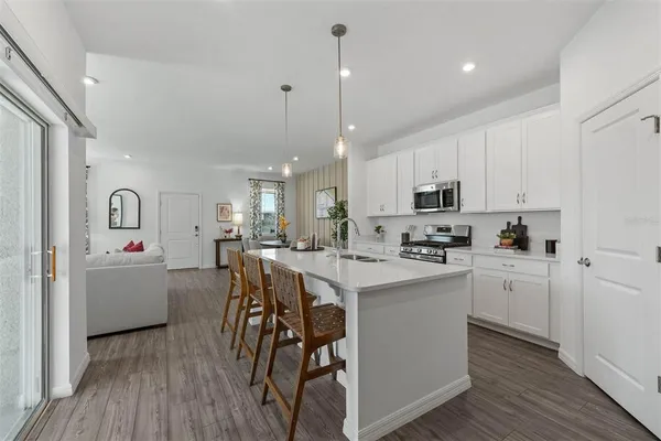 a kitchen with white cabinets and appliances