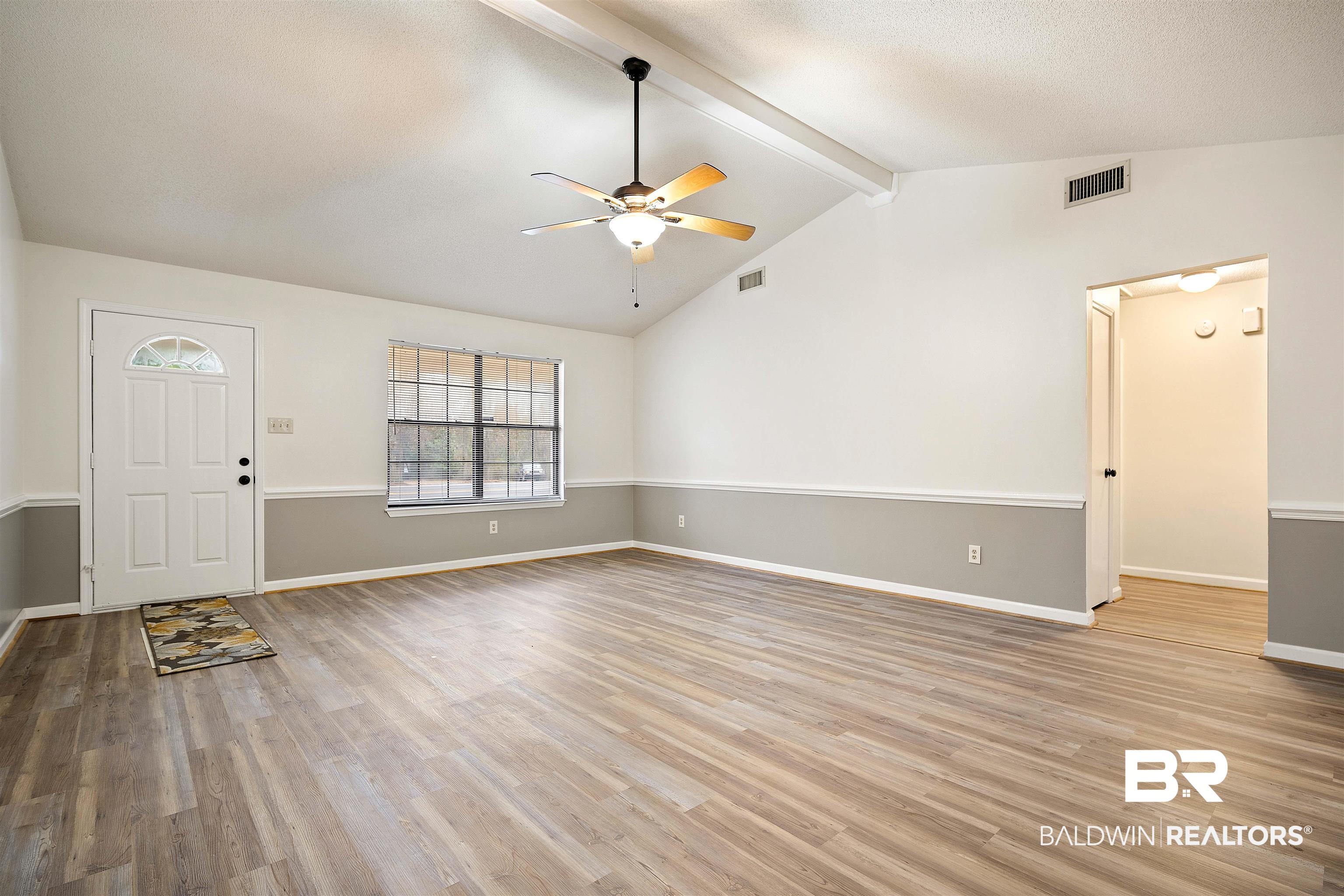 6701 Howells Ferry Road Mobile, AL 36618 - Photo 7 of 25 Unfurnished living room with vaulted ceiling with beams, ceiling fan, and light hardwood / wood-style flooring