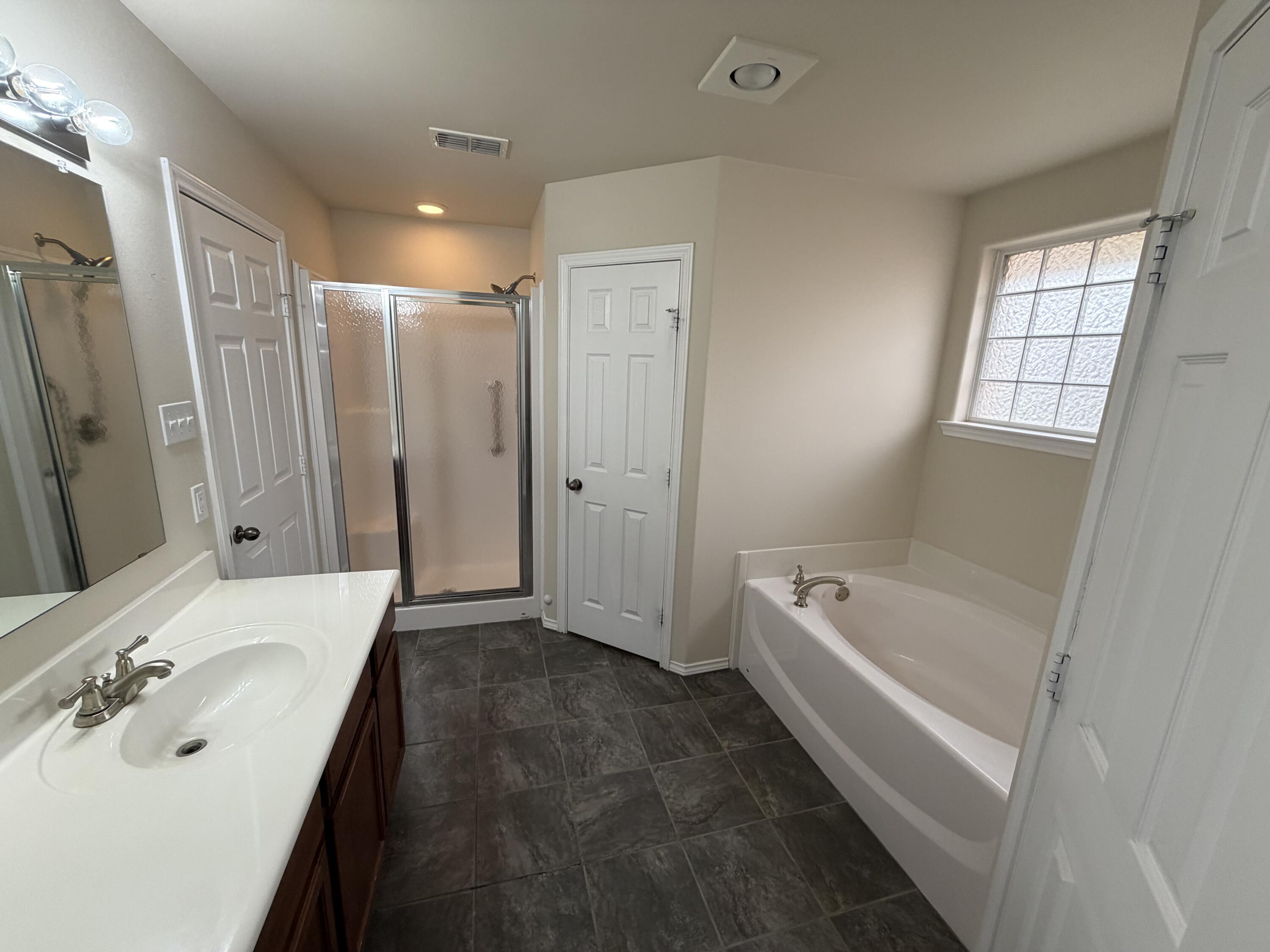 6544 84th Street Lubbock, TX 79424 - Photo 8 of 29 a spacious bathroom with a tub sink and mirror