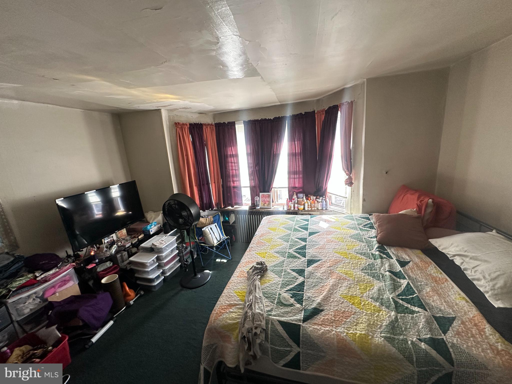 5024 Duffield Street Philadelphia, PA 19124 - Photo 14 of 18 a bed sitting in a bedroom next to a window and tv