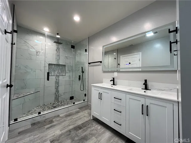 a bathroom with a shower sink vanity and mirror