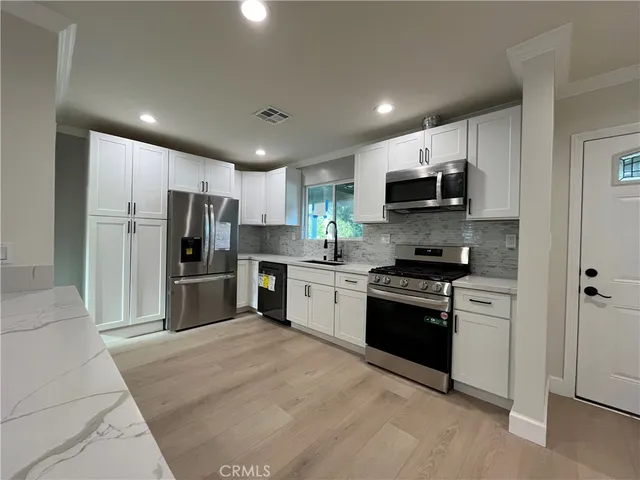a kitchen with stainless steel appliances a refrigerator sink and microwave