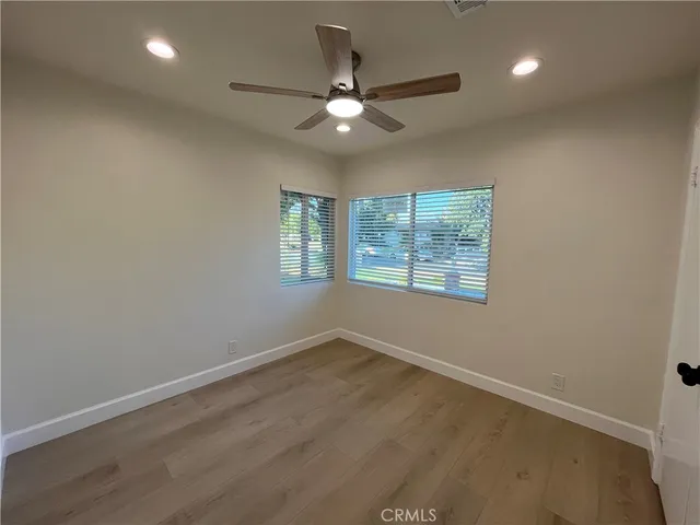an empty room with a window and a fan