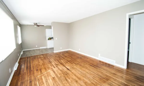 a view of empty room with wooden floor