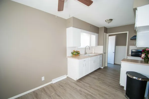 a kitchen with a refrigerator and white cabinets