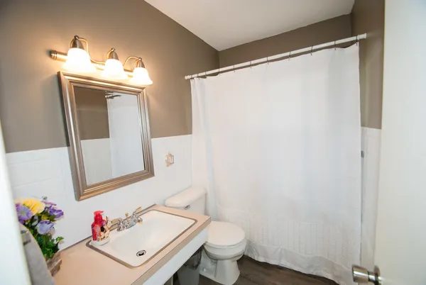 a bathroom with a sink toilet and mirror