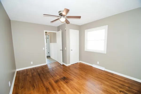 a view of a big room with wooden floor and windows in a room