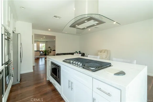 a kitchen with a stove a sink a refrigerator and cabinets
