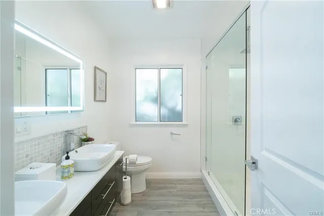 a bathroom with a sink a toilet and shower