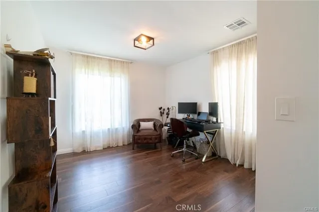 a view of a livingroom with workspace and a window
