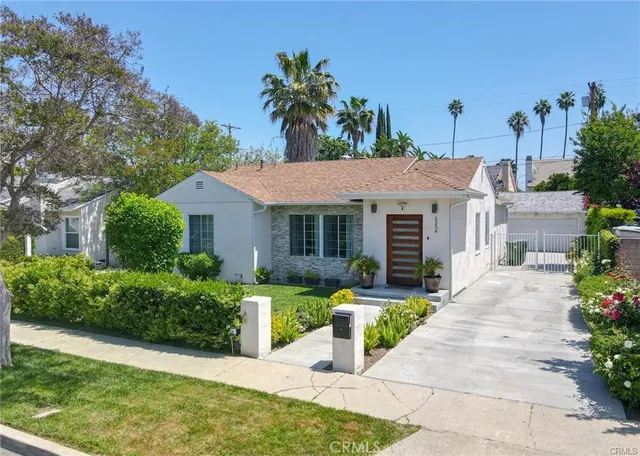 a front view of a house with a garden and plants