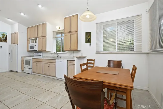 a kitchen with stainless steel appliances granite countertop a stove a sink a microwave a dining table and chairs