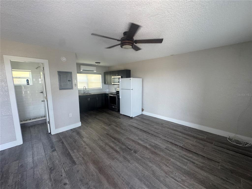 1896 Ocean Shore Boulevard Ormond Beach, FL 32176 - Photo 4 of 6 an empty room with wooden floor cabinet and windows