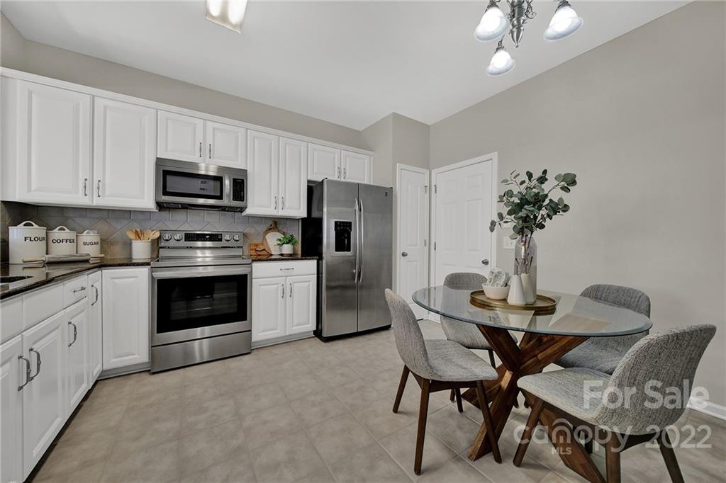 9168 Redmond Trace Road Charlotte, NC 28277 - Photo 6 of 24 a kitchen with stainless steel appliances kitchen island granite countertop a dining table and chairs