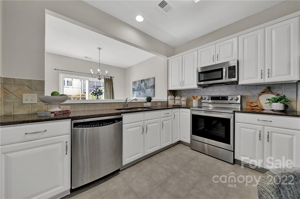 9168 Redmond Trace Road Charlotte, NC 28277 - Photo 7 of 24 a kitchen with granite countertop white cabinets and white appliances