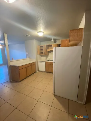 a kitchen with refrigerator and cabinets