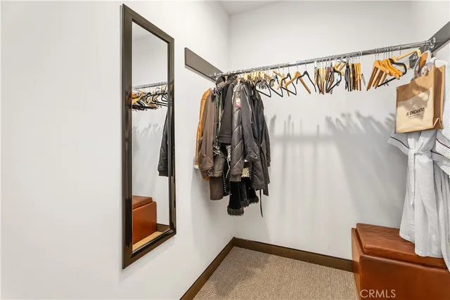 a view of walk in closet with clothes and shoes
