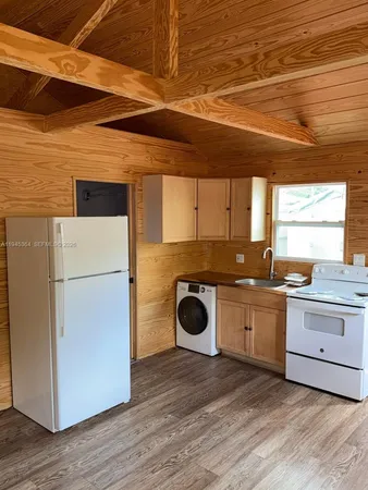 a kitchen with a refrigerator and white cabinets