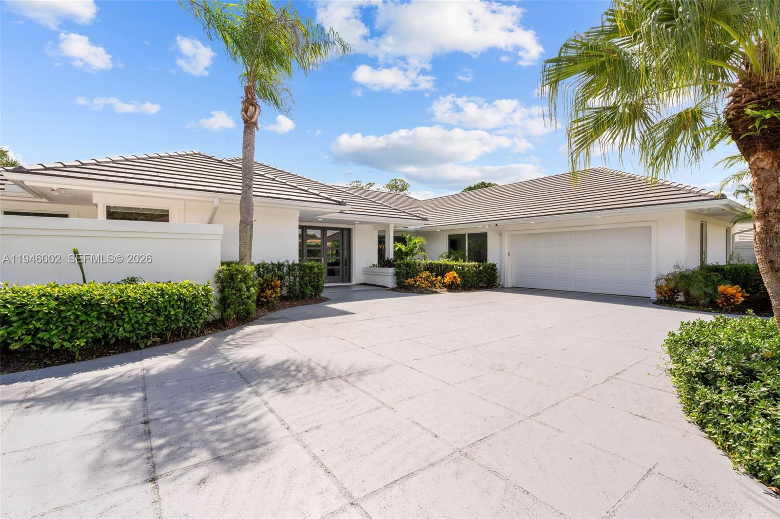 17 Surrey Road Palm Beach Gardens, FL 33418 - Photo 2 of 43 a front view of a house with a garden and palm trees