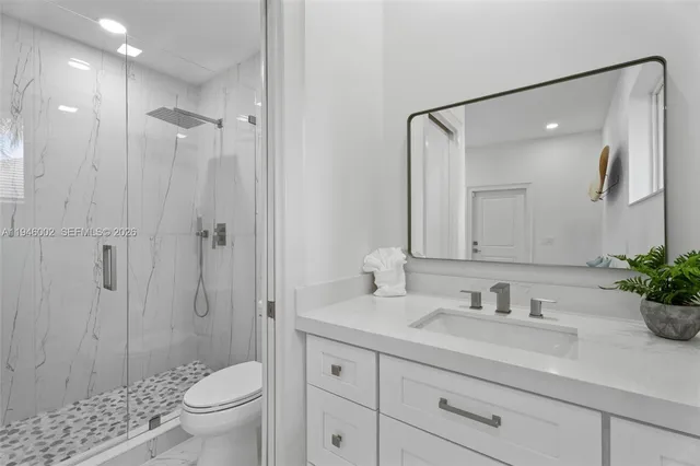 a bathroom with a sink a toilet and shower