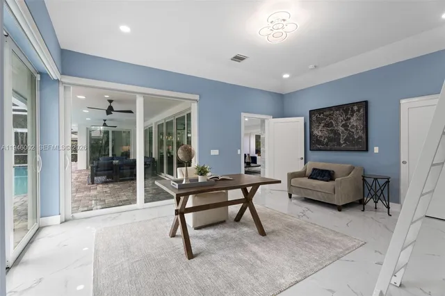 a living room with furniture and a floor to ceiling window