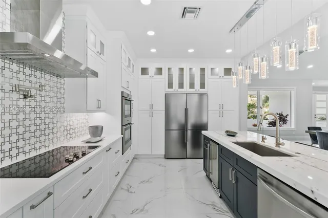 a large kitchen with a large counter top stainless steel appliances and cabinets