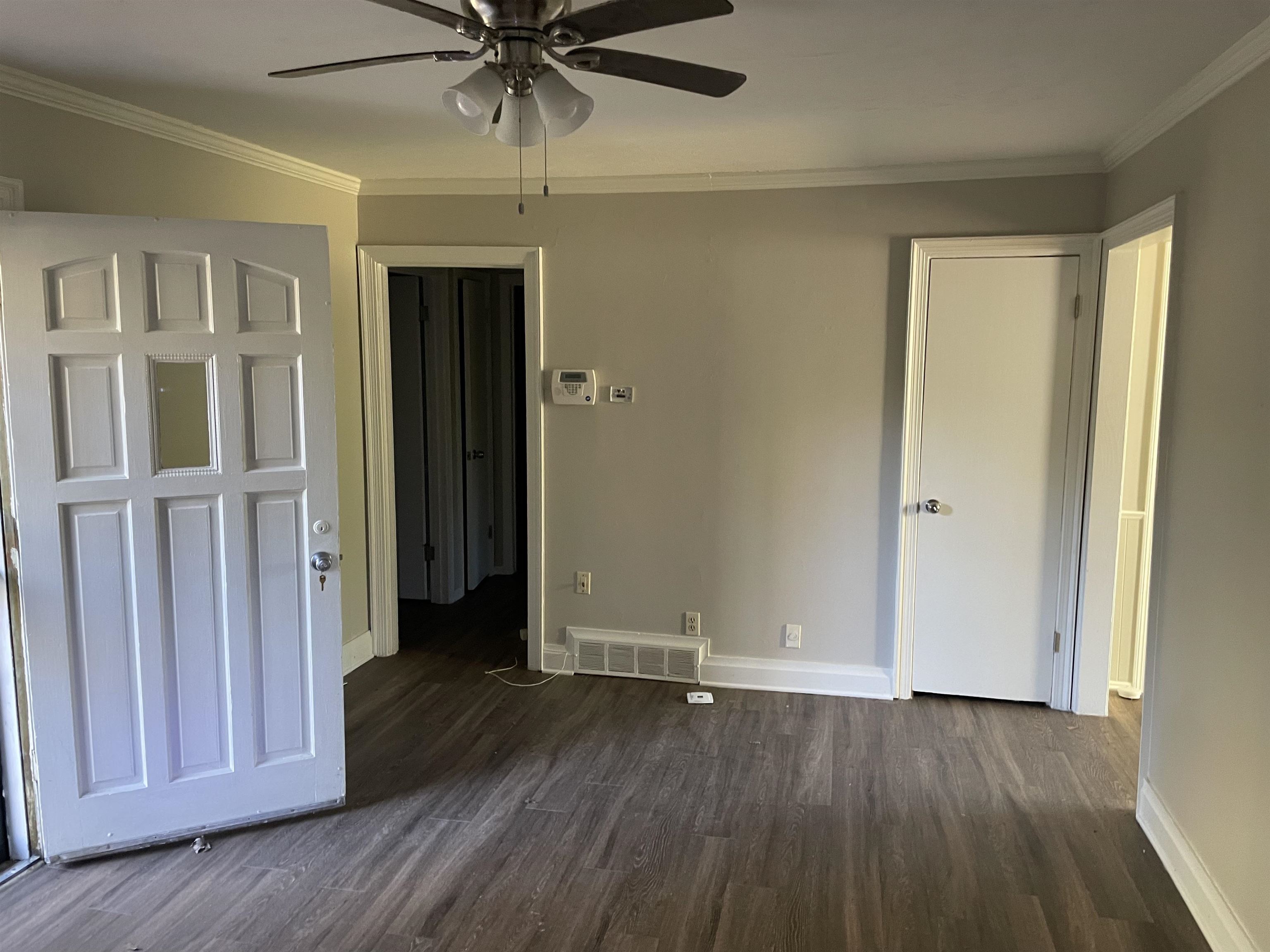 5433 Loch Lomond Road Memphis, TN 38116 - Photo 3 of 4 an empty room with wooden floor a ceiling fan and windows