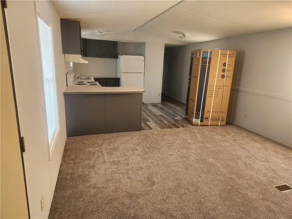 a view of a kitchen with refrigerator and front door