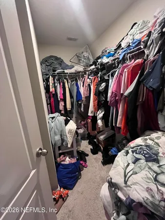 a view of walk in closet with clothes and shoes