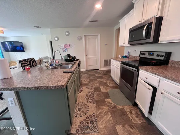 a kitchen with stainless steel appliances granite countertop a sink stove and microwave
