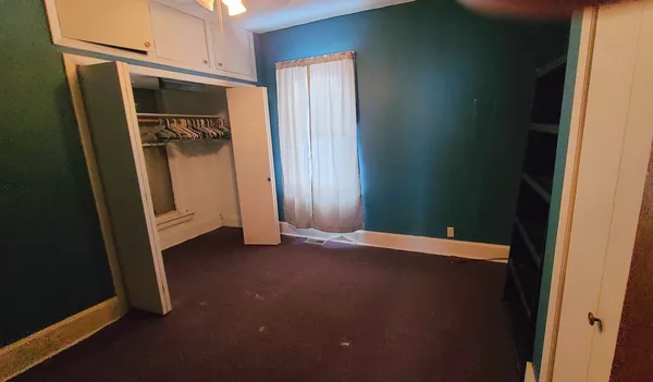 a view of an empty room with closet
