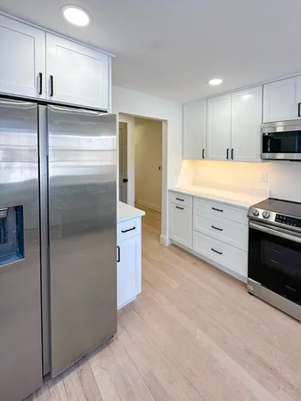 a kitchen with stainless steel appliances granite countertop a refrigerator a sink and a stove