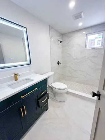 a bathroom with a bathtub sink mirror and toilet