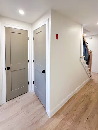 a view of a hallway with wooden floor and staircase
