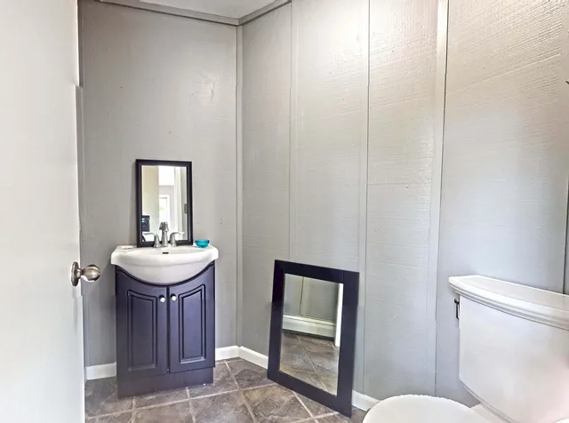 a bathroom with a sink a toilet and mirror