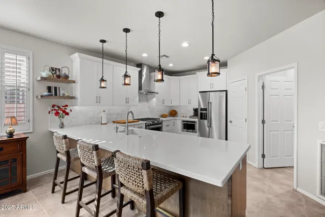 a kitchen with granite countertop a table chairs and white cabinets