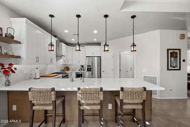 a kitchen with a dining table chairs and white cabinets