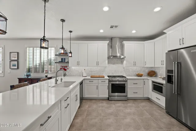 a large kitchen with stainless steel appliances kitchen island granite countertop a sink a stove and a refrigerator