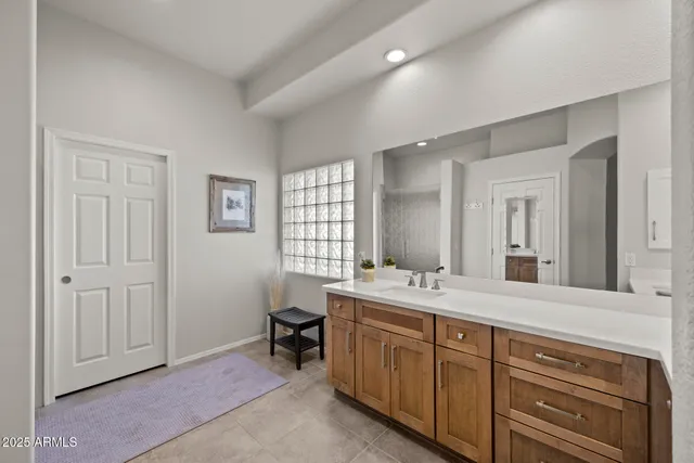 a spacious bathroom with a double vanity sink a mirror and a bathtub