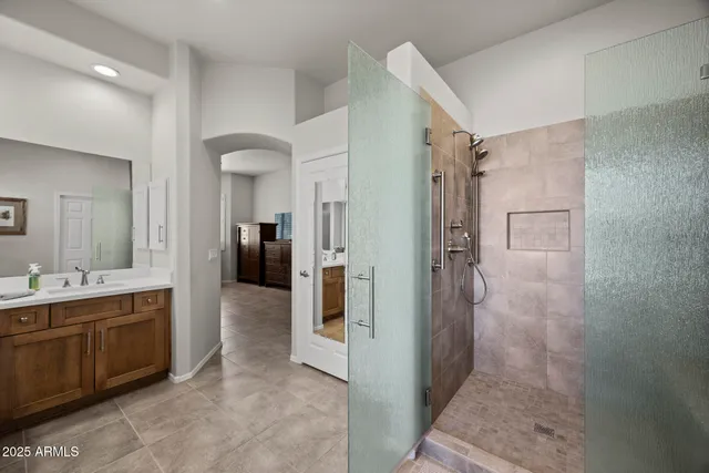 a bathroom with a double vanity sink a toilet and shower