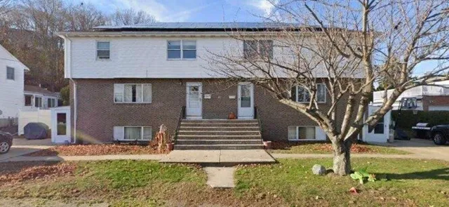 a view of a house with a yard and large tree