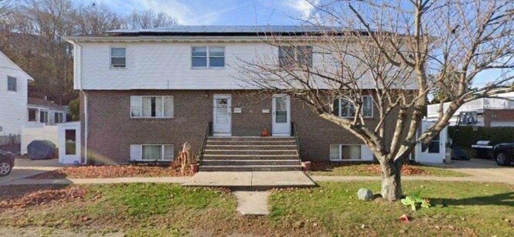 a view of a house with a yard and large tree