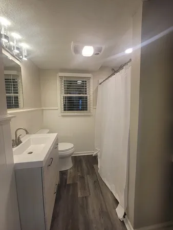 a bathroom with a sink a toilet and shower