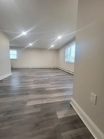 a view of empty room with wooden floor