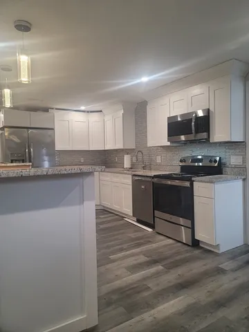 a kitchen with stainless steel appliances granite countertop a stove top oven a sink and a microwave